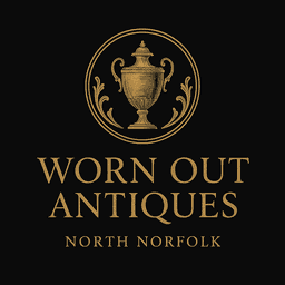 Black and white photograph of a family standing outside a vintage antiques shop on its opening day, accompanied by a Winston Churchill impersonator. The shop sign reads 'Worn Out,' and the image is now used as part of the business logo and story on the website